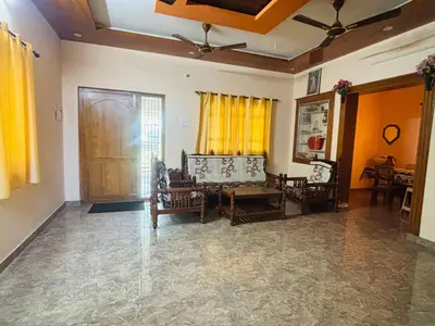 a living room with two chairs and a table at RoBen Villa in Pollāchi