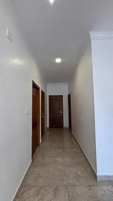 an empty hallway with white walls and wooden doors at Blessing holidays ooty in Ooty