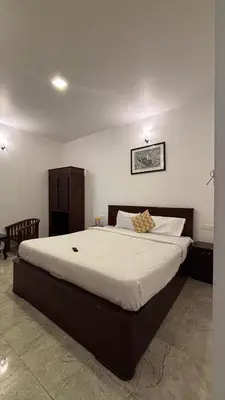 a bedroom with a large bed with white sheets at Blessing holidays ooty in Ooty