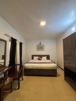 a bedroom with a bed and a bench and a table at Blessing holidays ooty in Ooty