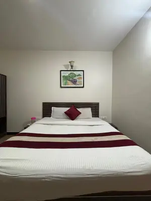 a bedroom with a large white bed with red pillows at Blessing holidays ooty in Ooty