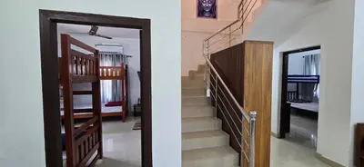 a stairway leading to a bedroom and a hallway at Brighton Hostel Stays in Sultan Bathery
