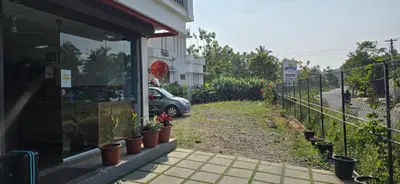 a car parked next to a building with potted plants at Brighton Hostel Stays in Sultan Bathery