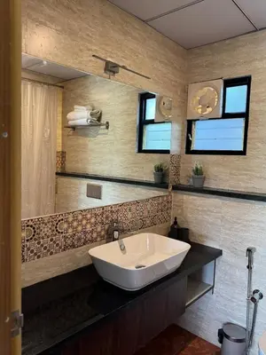 a bathroom with a sink and a mirror at Bhoomi in Mysore