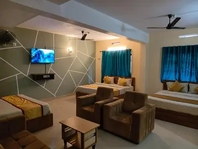 a living room with two beds and a couch at Hill View Residency in Kalpetta