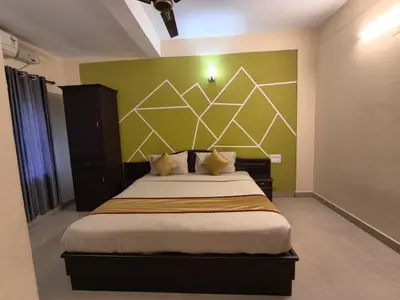 a bedroom with a bed with a green wall at Hill View Residency in Kalpetta