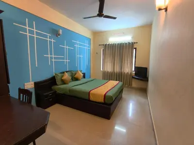a bedroom with a bed with a blue wall at Hill View Residency in Kalpetta