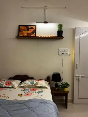 a bedroom with a bed and a shelf on the wall at Hazel's ELiTE Homestay 2bhk in Mysore