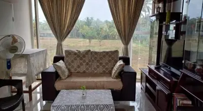 a living room with a couch and a large window at GG Home stay in Pollāchi