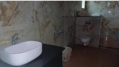 a bathroom with a sink and a toilet at GG Home stay in Pollāchi