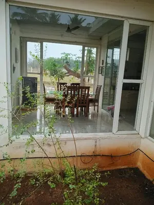 a screened in porch with a table and chairs at GG Home stay in Pollāchi