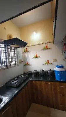a kitchen with a stove and a counter top at Steeva Guest house in Mysore