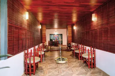 a restaurant with red chairs and a fountain in a room at Gokulam Grand Resort & Spa, Coorg in Kushālnagar