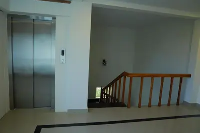a hallway with a staircase and a glass elevator at Anna Residency in Nedumbassery