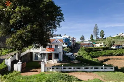 a house with a white fence in a town at Zostel Ooty in Ooty