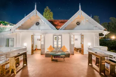 a white house with a table in front of it at Zostel Ooty in Ooty
