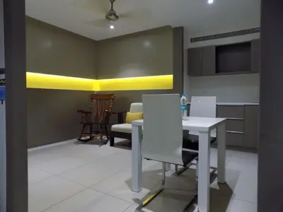 a dining room with a white table and chairs at ZIBE Coimbatore by GRT Hotels in Coimbatore
