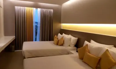 a hotel room with two beds and a window at ZIBE Coimbatore by GRT Hotels in Coimbatore