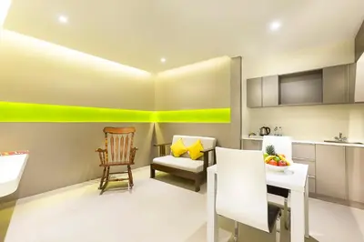 a kitchen with a table and a chair and a kitchen with yellow accents at ZIBE Coimbatore by GRT Hotels in Coimbatore