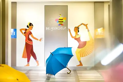 a mural of a woman with an umbrella at ZIBE Coimbatore by GRT Hotels in Coimbatore