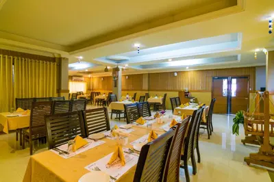 a dining room with tables and chairs in a restaurant at Sree Gokulam Residency in Trichūr