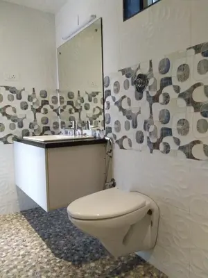 a bathroom with a toilet and a sink at Darshan Hotel in Ooty