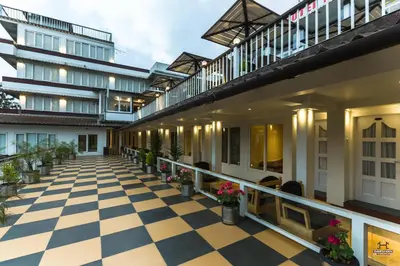 an indoor courtyard of a building with a checkered floor at Darshan Hotel in Ooty