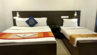 a hotel room with two beds with towels on them at Half Moon Residency Calicut in Kozhikode
