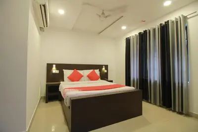 a bedroom with a bed with red pillows at Half Moon Residency Calicut in Kozhikode