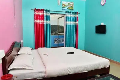 a bed in a room with colorful walls and a window at RK Holiday Home in Ooty