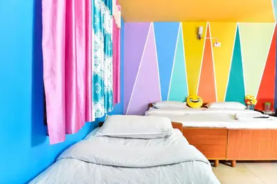 two beds in a room with colorful walls at RK Holiday Home in Ooty