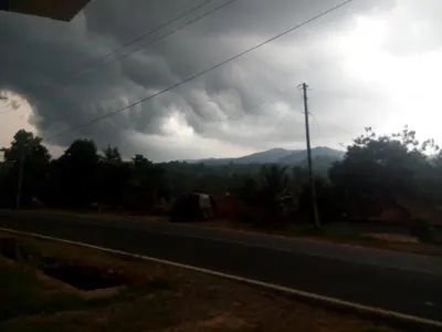 a stormy sky with a truck on the side of a road at Green Villa in Virajpet