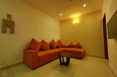 a living room with a couch and a table at Sara Hotels and Apartments in Nedumbassery