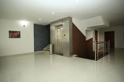 a hallway with a metal elevator in a building at Sara Hotels and Apartments in Nedumbassery