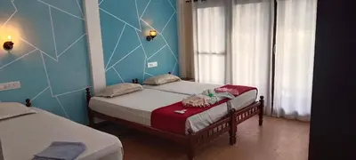 two twin beds in a room with blue walls at Cherai Ocean View Home in Cherai Beach
