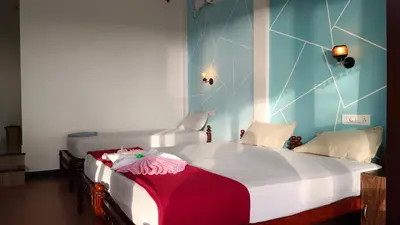 a bedroom with a large white bed with a red blanket at Cherai Ocean View Home in Cherai Beach