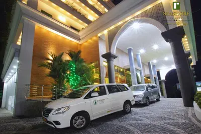 a white car parked in front of a building at Seashore Residency in Kodungallūr