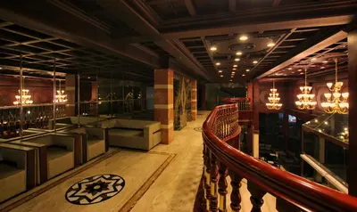 a lobby of a bar with a couch and chairs at Seashore Residency in Kodungallūr
