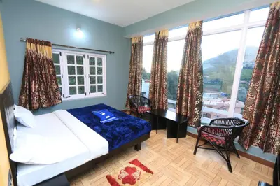 a bedroom with a bed and a large window at The Black Magic Cottage in Ooty