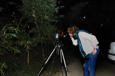a man looking into a camera on a tripod at Pugmarks Jungle Resort in Chekadi