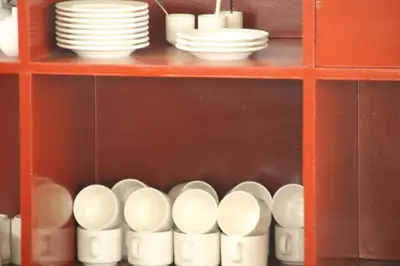 a shelf filled with plates and cups and dishes at Petit Elephant in Cherai Beach