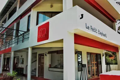 a building with a red sign on the side of it at Petit Elephant in Cherai Beach