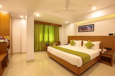 a bedroom with a large bed with a green curtain at Hotel Park Residency Calicut in Kozhikode