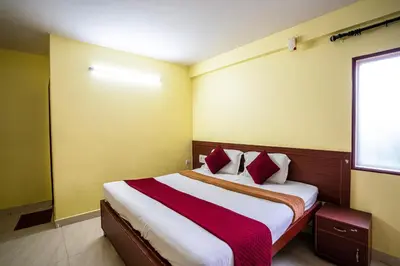 a bedroom with a large bed with red and white pillows at Hotel Vyshak residency in Mysore