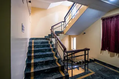a spiral staircase in a room with a window at Hotel Vyshak residency in Mysore