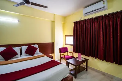 a hotel room with a bed and a red curtain at Hotel Vyshak residency in Mysore