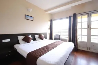 a bedroom with a large bed and a large window at The Hill Side in Ooty