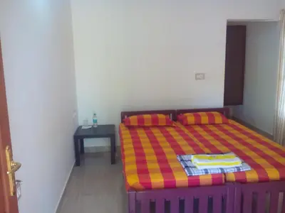 a small bedroom with a bed and a table at Ivory Coaste in Kannur