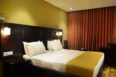 a bedroom with a large bed in a hotel room at Ranis Grand in Coimbatore