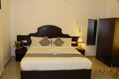 a bedroom with a large bed with a black headboard at Ebenezer Plaza in Nedumbassery